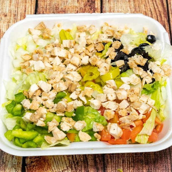 A Big T's Pizza salad with chicken, lettuce, green peppers, tomatoes, black olives, and banana peppers.