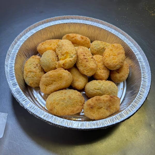 Golden-brown Big T's Pizza jalapeño poppers, breaded and fried, served in a round aluminum takeout container.